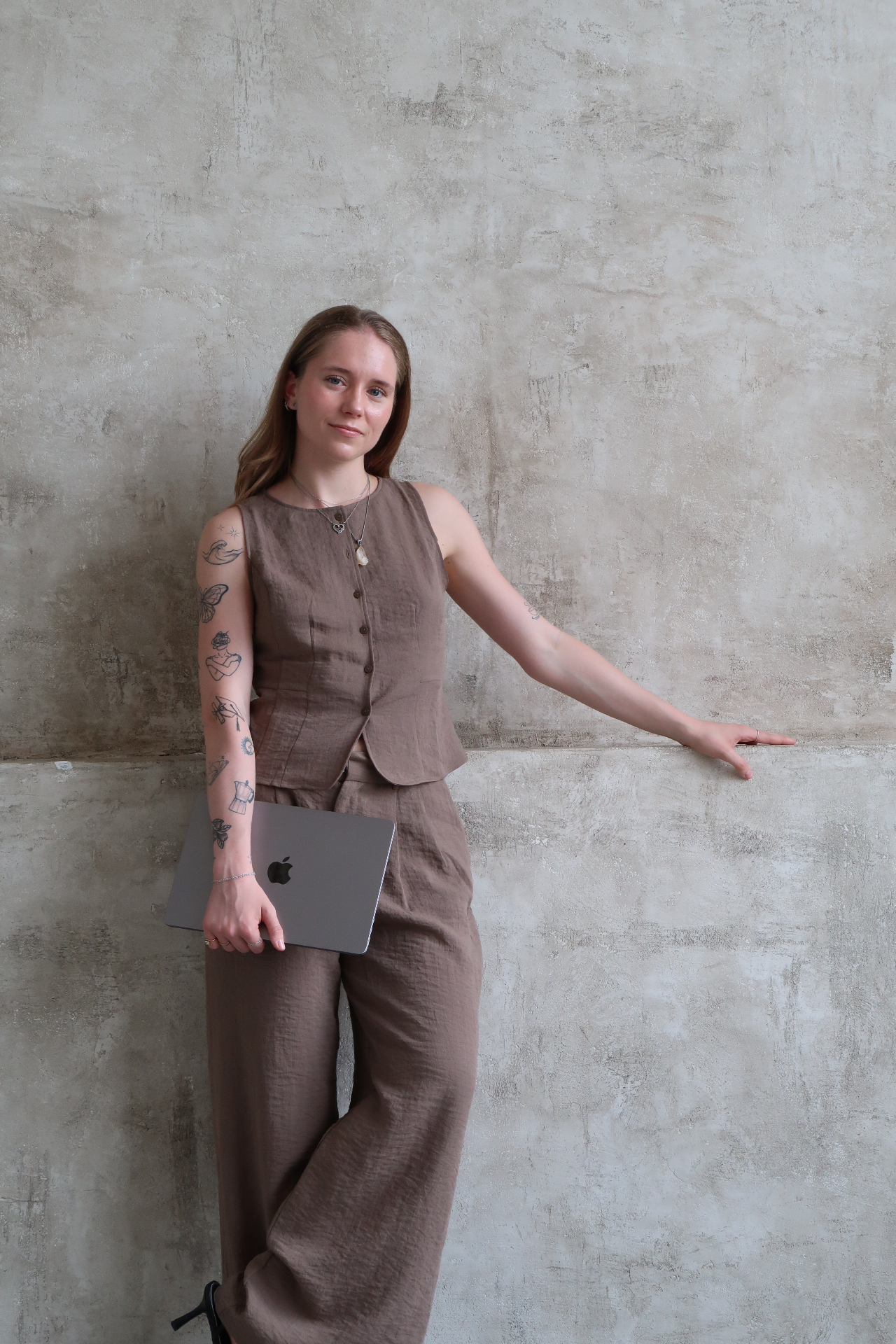 Tereza Schýbalová — portrét u betonové zdi s notebookem